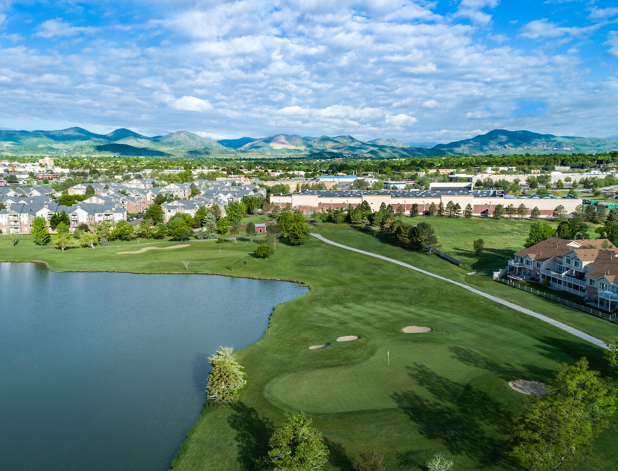 Aerial view of Raccoon Creek Golf Course clubhouse at dusk with golf carts