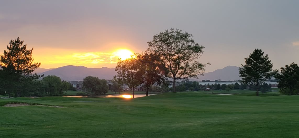 Aerial view of Raccoon Creek Golf Course at dusk showing full clubhouse and course grounds